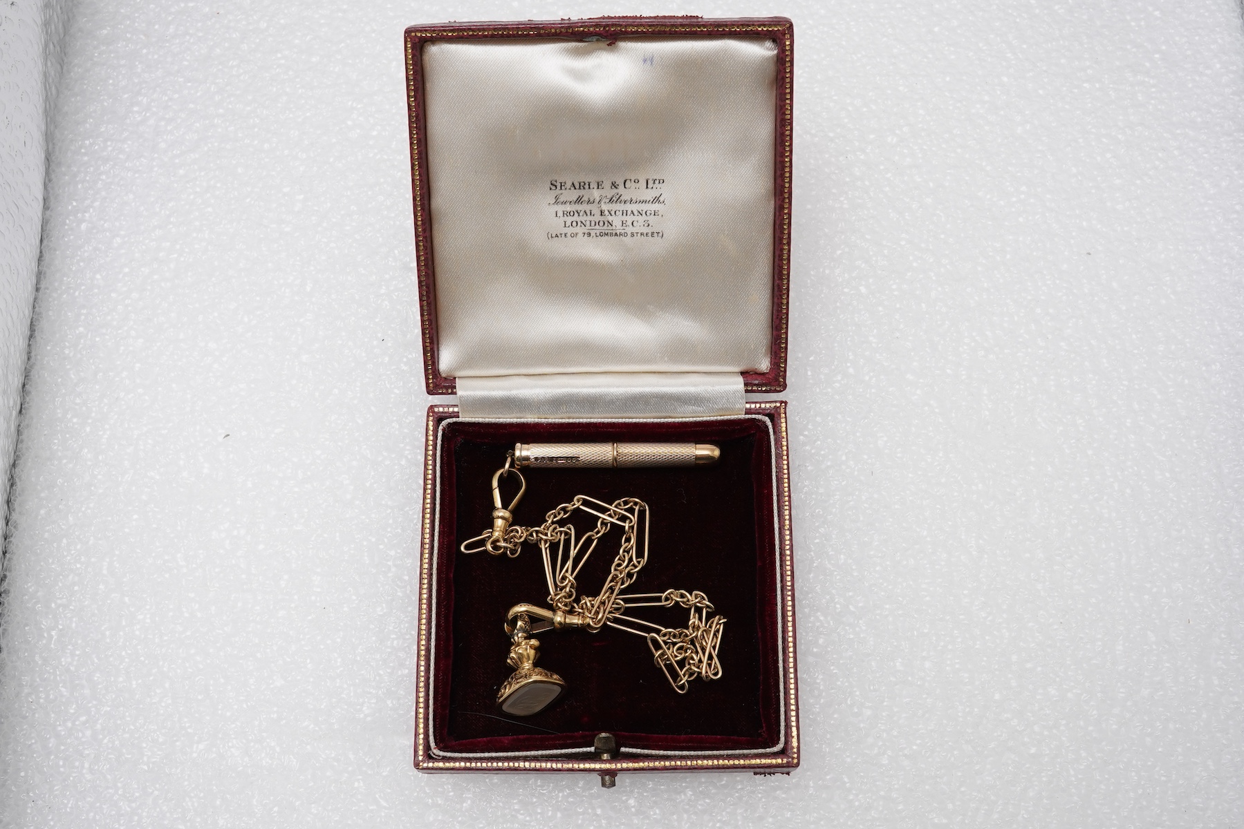 A gold watch chain, toothpick and fob seal